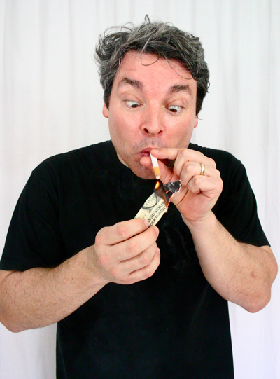 bRIAN j. fOLEY lights the wrong end of a cigarette with a burning bill